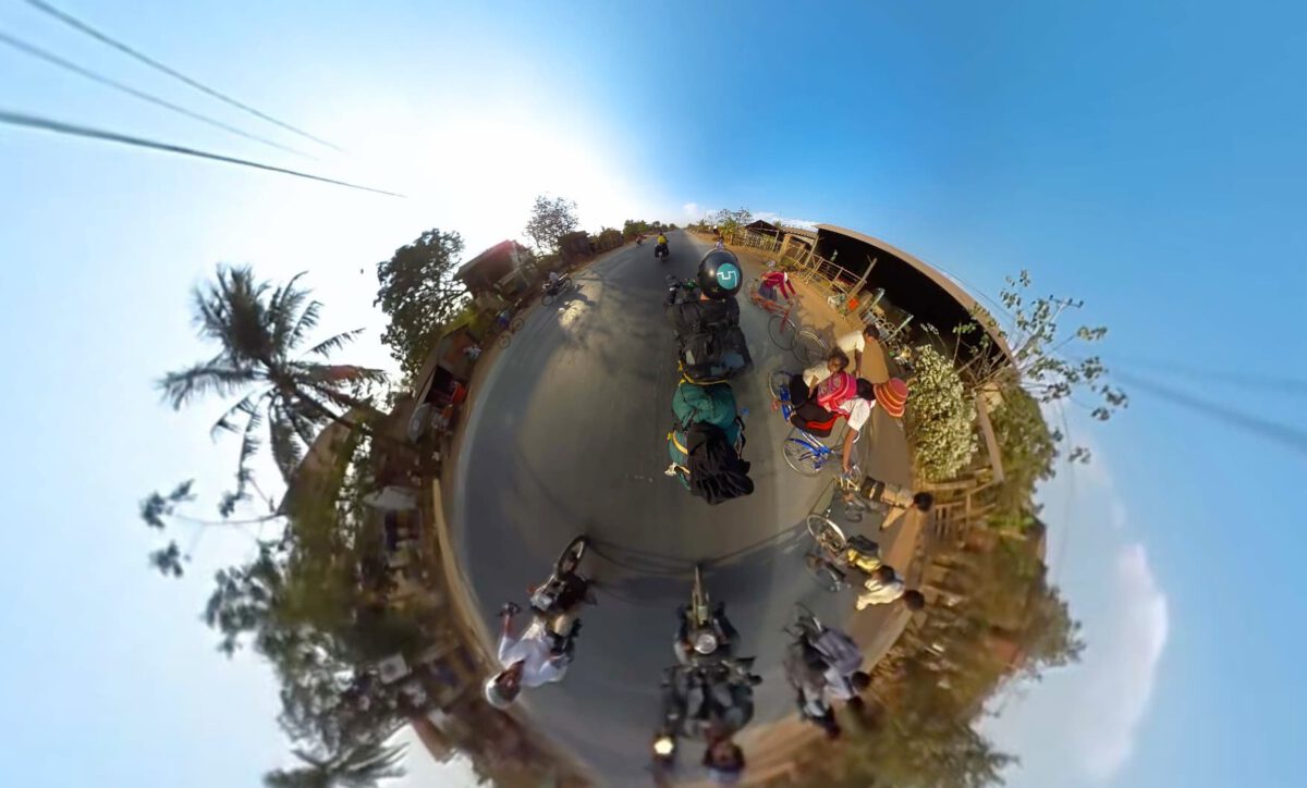 Tiny-Planet-Ansicht einer 360-Grad-Aufnahme mit Radfahrenden und Mopeds auf einer Straße