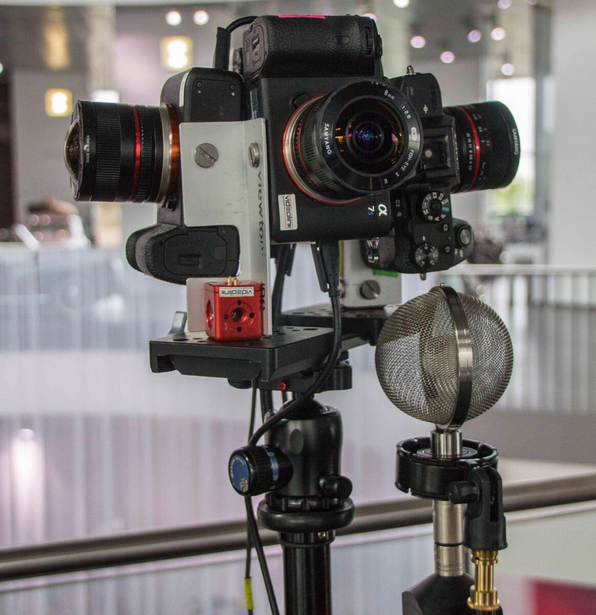 360-degree camera rig with several lenses and an ambisonic microphone mounted on a tripod