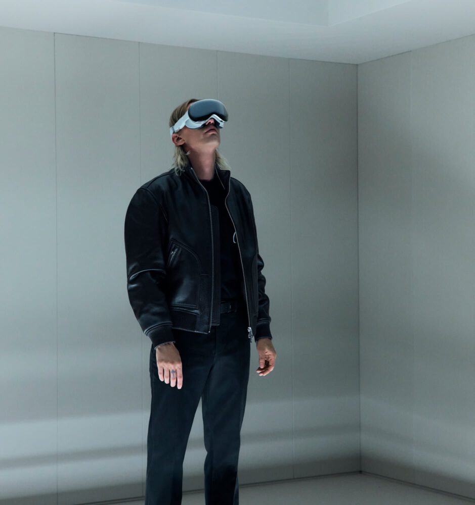 Person wearing Apple Vision Pro VR headset experiencing immersive spatial audio in minimalist environment