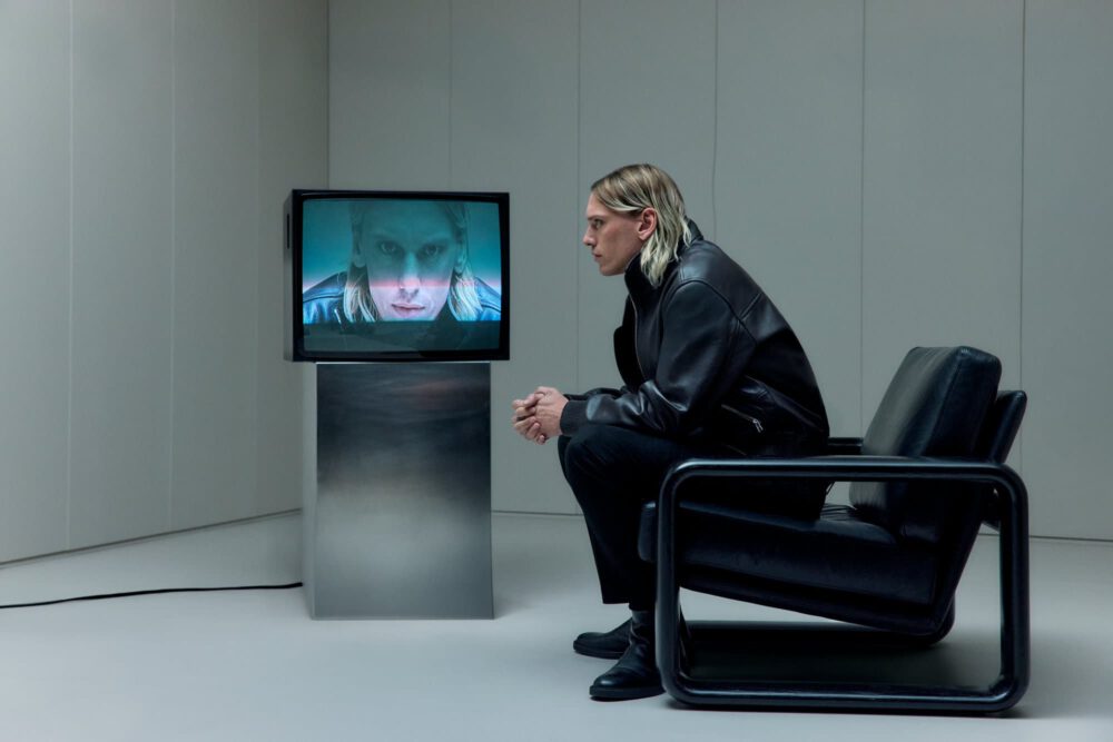 Person experiencing immersive spatial audio installation at BOSS x Aston Martin F1 event with interactive monitor