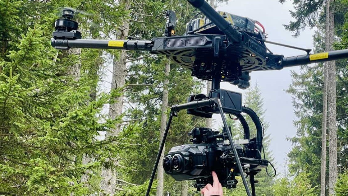 Drone carrying a stereoscopic immersive camera rig above a mountain forest location