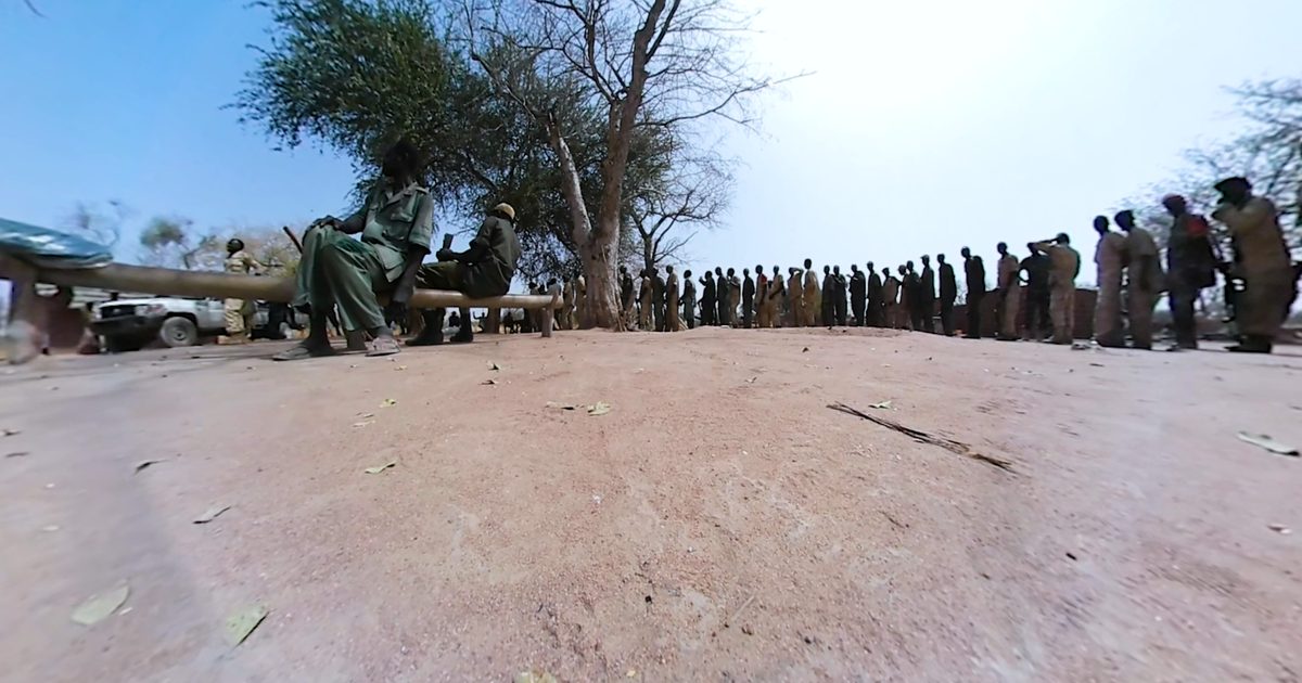 Lange Reihe uniformierter Maenner unter Baeumen in den Nuba-Bergen, 360-Grad-Filmstill aus Blended Isolation