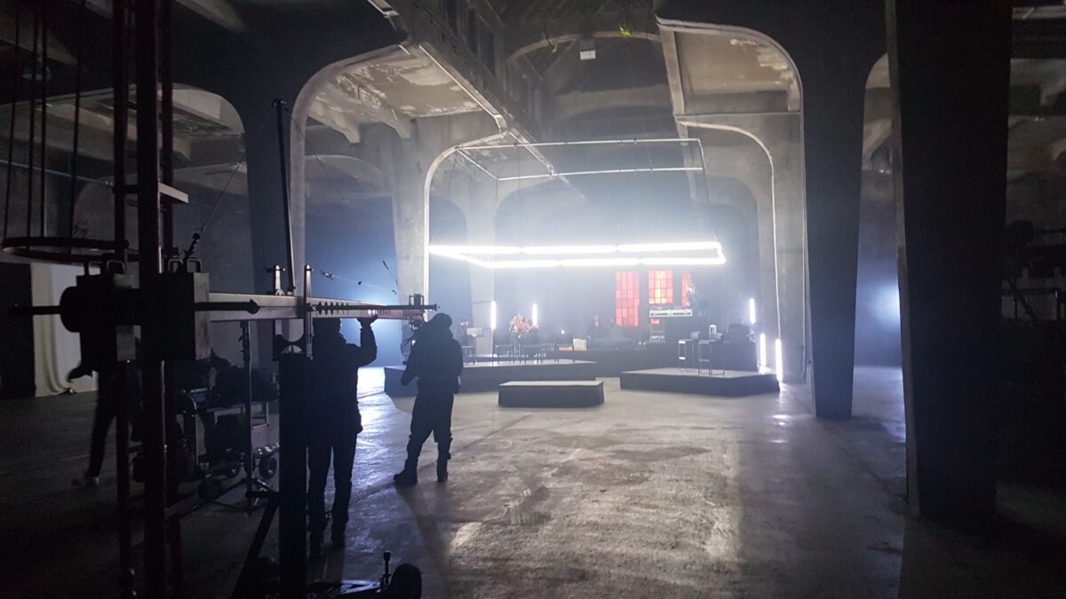 Filmcrew mit Kamerakran in einer Industriehalle beim Dreh von Audi Schwarm Symphony