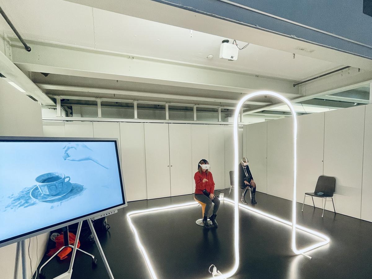 Zwei Besucher mit VR-Headsets in der Emperor-Installation mit Neonlicht-Markierung