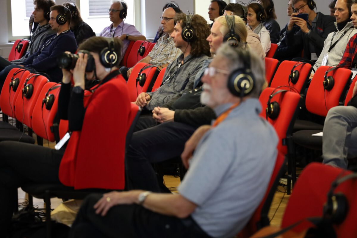 Audience listening on headphones during a listening session at the ICSA conference