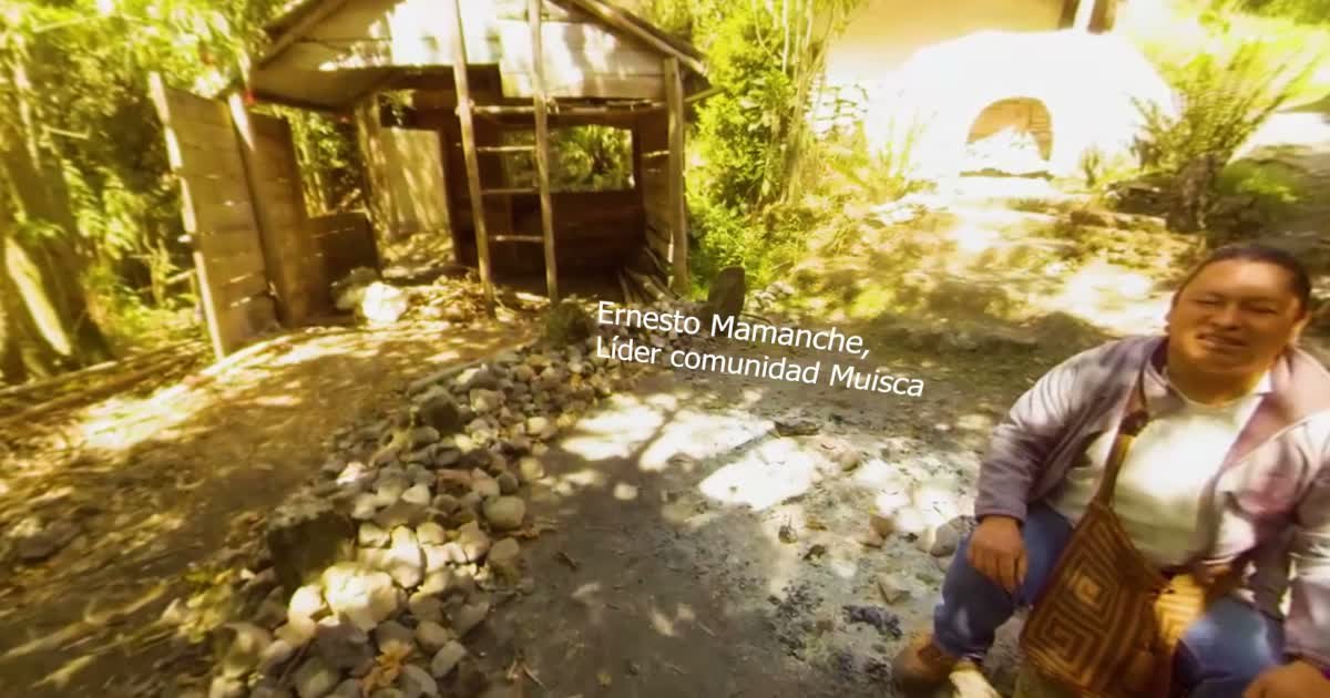 Ernesto Mamanche, Anfuehrer der Muisca-Gemeinschaft, sitzt vor einer Huette im Wald