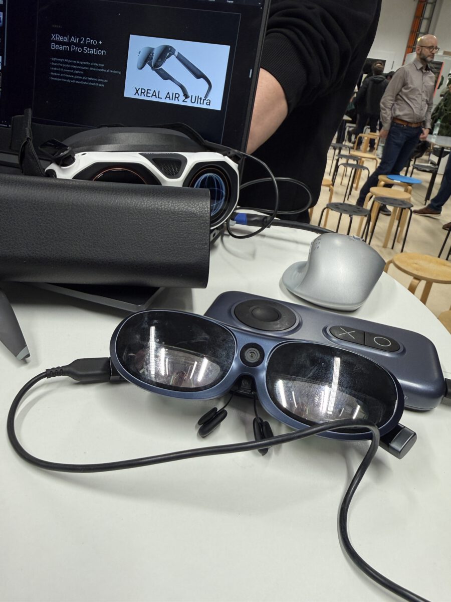 XREAL Air 2 Ultra smart glasses on display at a trade show booth, with product signage in the background