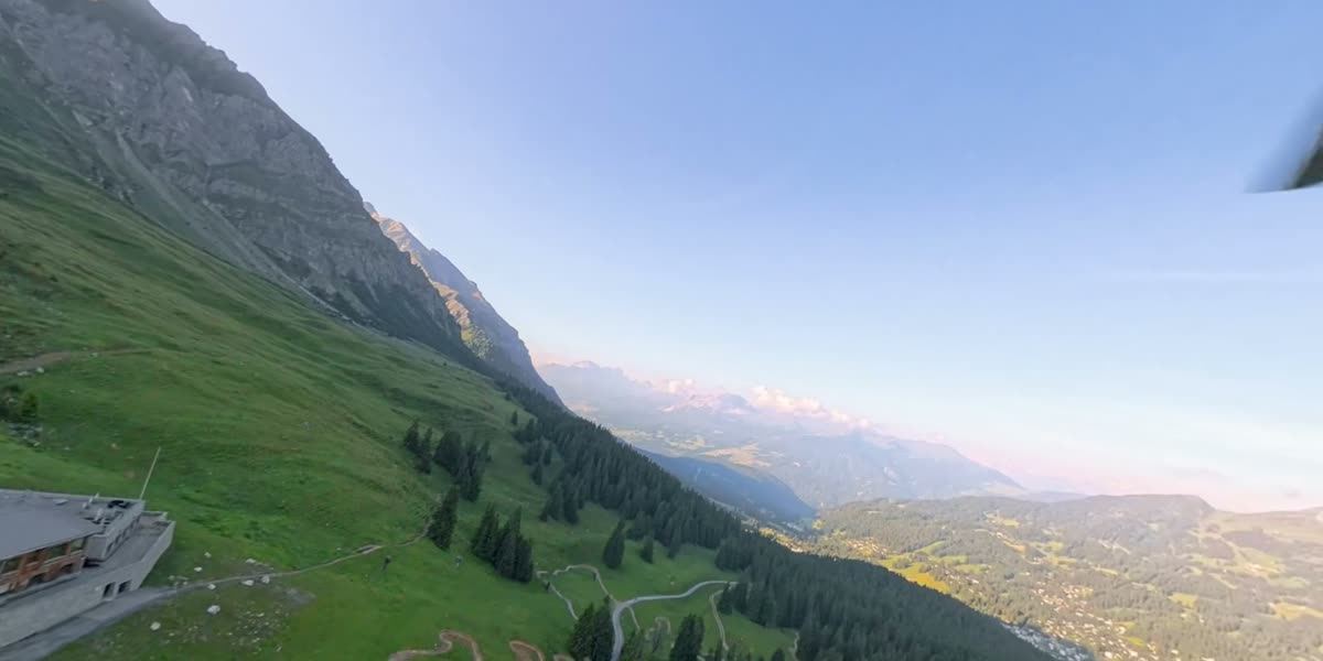 Aerial view over an alpine landscape with a mountain station, film still from the 360-degree video shot from the helicopter