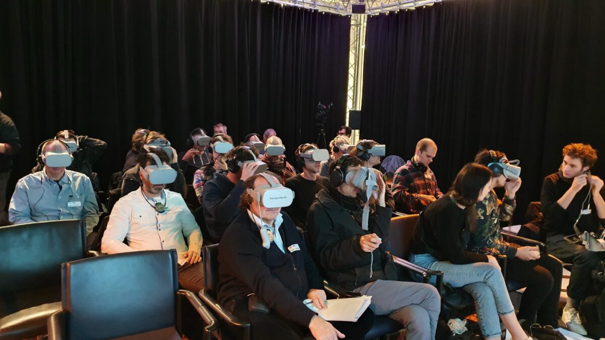 Publikum mit VR-Brillen im Saal während einer Vorführung für immersiven Ton